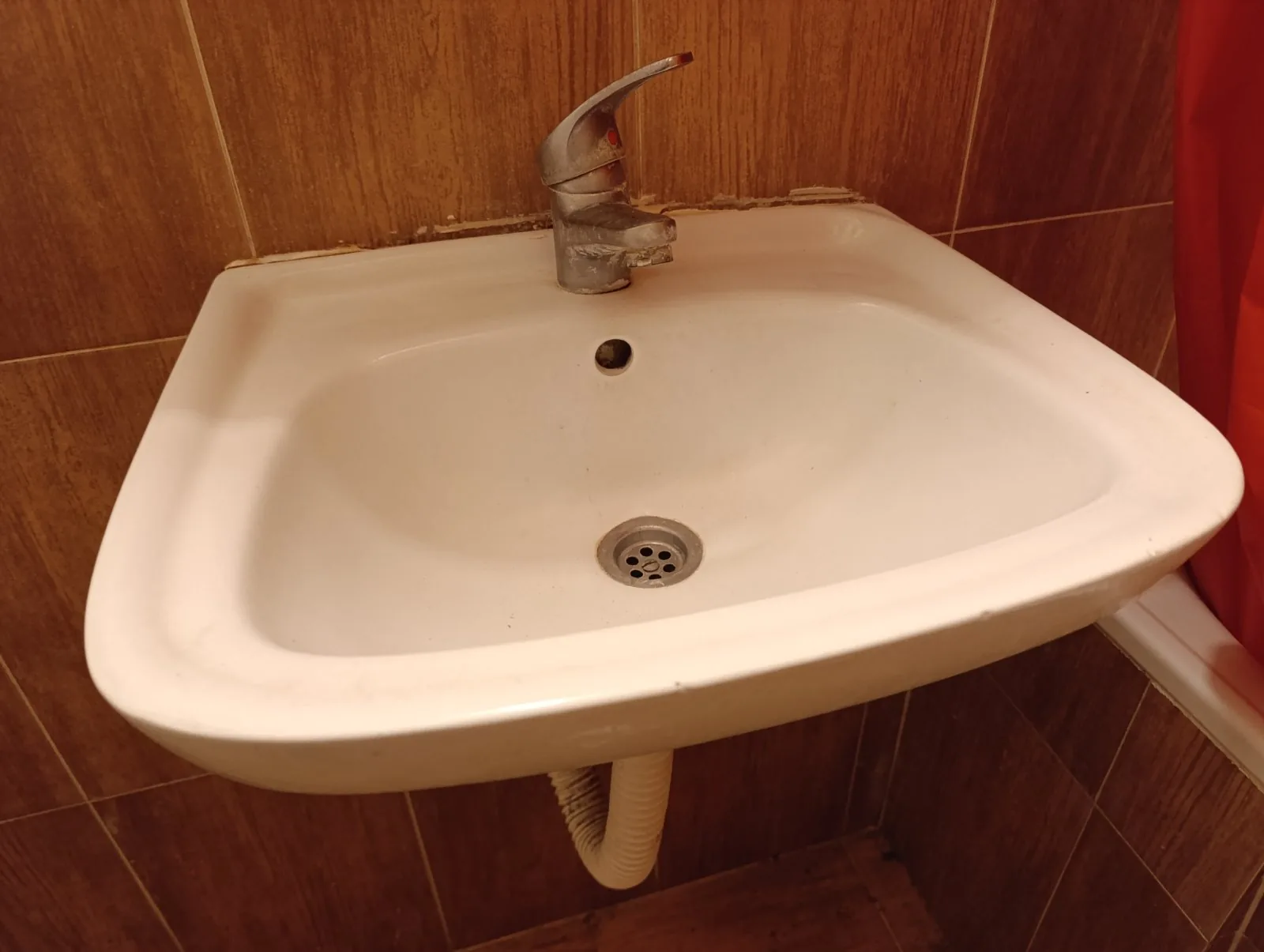 Stari umivaonik sa dotrajalom baterijom pre zamene — vodoinstalater Pantelej, Niš